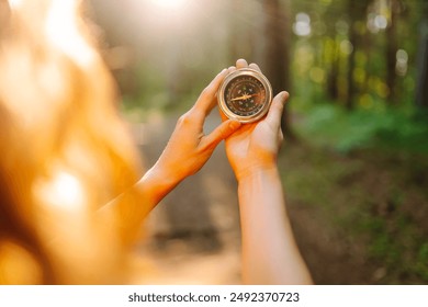 Hands of woman holding navigational compass. Female traveler holding compass in hands and navigating in nature. The concept of hiking, nature. - Powered by Shutterstock