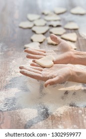 Hands Of Woman Holding One Of Raw Cookies In Shape Of Heart While Cooking Homemade Pastry