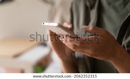 Hands of woman holding smartphone, using online app and virtual services cellphone, making video phone call, texting and chatting on messengers, buying online, reading books, articles. Close up