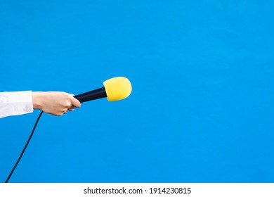 Hands Of A Woman Holding A Yellow Microphone With Copy Space, Interview Concept.