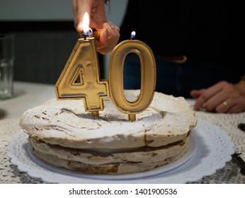 Hands Of A Woman Lighting Golden Candles Four And Zero Of A Birthday Cake Celebrating 40th Aniversary 