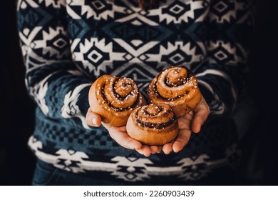 hands of woman making cinnamon rolls at table, recipe ingredients 