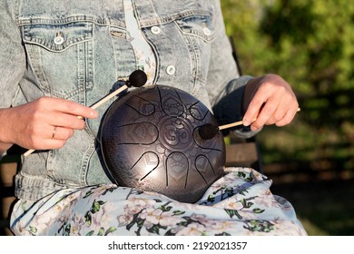 Hands Of Woman Musician Playing Steel Tongue Drum,music And Instrument. The Inscription In Sanskrit OM