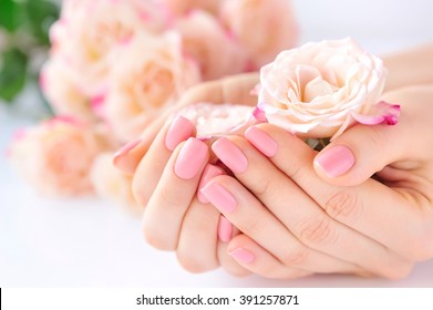 Hands Of A Woman With Pink Manicure On Nails And Roses