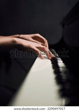 Hands of a woman playing piano.