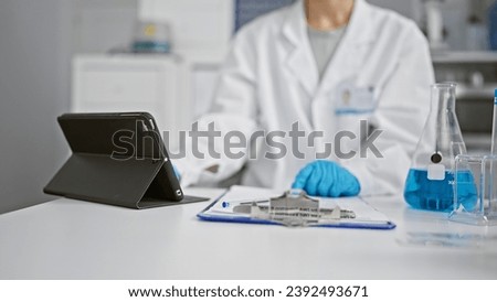 Hands of woman scientist using touchpad at laboratory