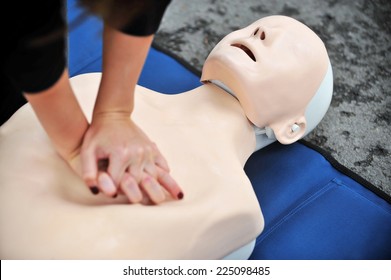 Hands of a woman are seen on a mannequin during an exercise of resuscitation