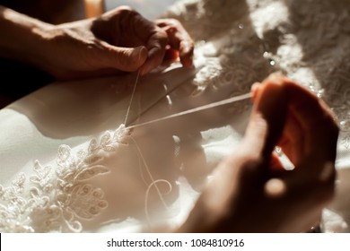 Hands Of Woman Are Sewing The Wedding Dress. No Face. Close-up. Tailor Concept