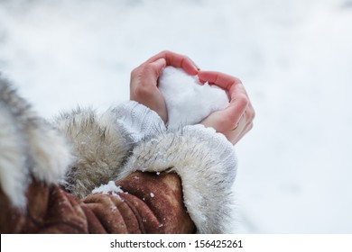 Hands Of Woman With Snow Heart In Winter