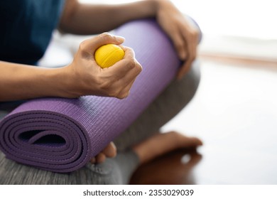 Hands of a woman squeezing a stress ball on the yoga mat, work out concpet - Powered by Shutterstock