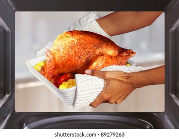 Hands Of Woman Is Taking Out  Turkey With Potato From Oven