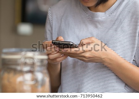 Hands of a woman using a mobile cell phone.