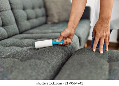 Hands Of Woman Using Pet Hair Remover Roller At Home.