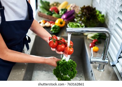 Hands woman  washing vegetables broccoli and tomatoes. Preparation of fresh salad. Fresh vegetables on the worktop near to sink in a modern kitchen interior, healthy food concept. Selective focus.
 - Powered by Shutterstock