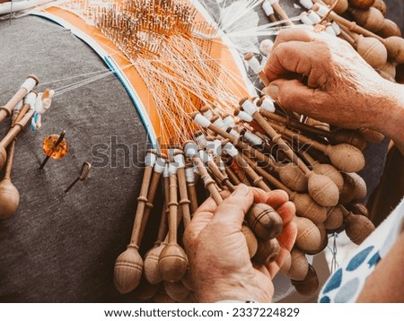 Hands of a woman weaving bobbin lace in a workshop. Lacemaker woman at work, traditional lace making crafts, folk art, selective focus