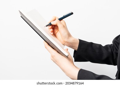 Hands of a woman writing notes in a notebook - Shutterstock ID 2034879164