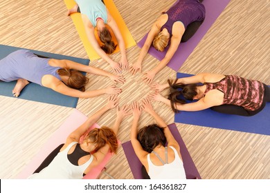 Hands of the women forming circle at Yoga class