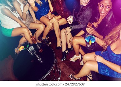 Hands, women or friends in nightclub with drinks, glass or cocktails for lounge, event or reunion. Legs, relax or people on dark disco party couch for fashion, alcohol or social celebration in group - Powered by Shutterstock