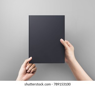 Hands women holding black book cover blank top view.  Blank book cover.