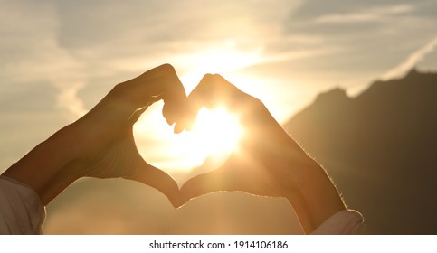 The Hands Of Women And Men Are The Heart Shape With The Sun Light Passing Through The Hands