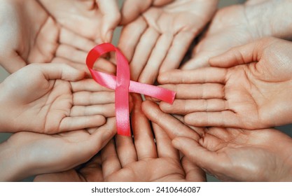 Hands of women with pink satin ribbon symbolizing concept of illness awareness, expressing solidarity and support for cancer patients and survivors. Different generations of people - Powered by Shutterstock