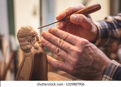 Hands of a wood sculptor working on a small wooden figure - Powered by Shutterstock