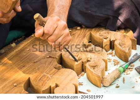 Hands woodcarver while working with the tools