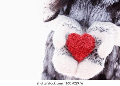 Hands In Woolen Mittens Holding Red Heart