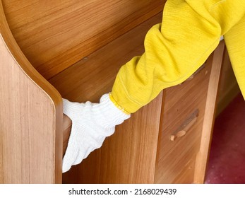 Hands With Work Gloves Carrying A Study Desk