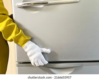 Hands with work gloves to move the refrigerator - Shutterstock ID 2166655957