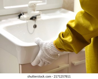 Hands with work gloves with a washbasin - Shutterstock ID 2171257811