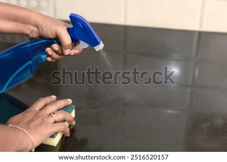 Hands work magic, transforming a messy kitchen into a sparkling sanctuary with a little cleaning spray and elbow grease.