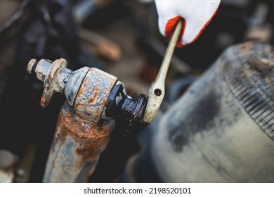 Hands Of Worker Repairing Car Parts In Auto Scrap.