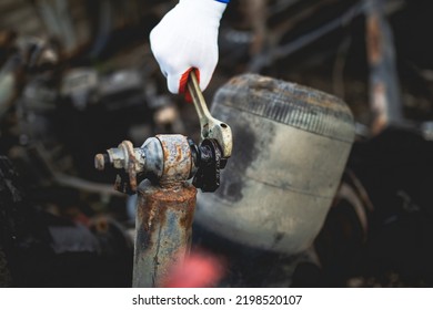 Hands Of Worker Repairing Car Parts In Auto Scrap.