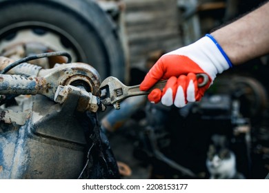 Hands Of Worker Repairing Car Parts In Auto Scrap.