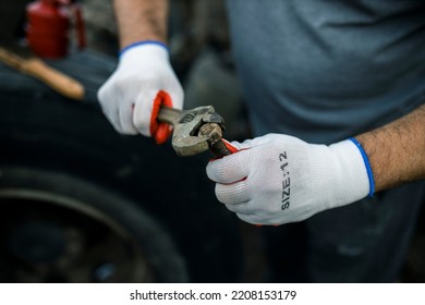 Hands Of Worker Repairing Car Parts In Auto Scrap.