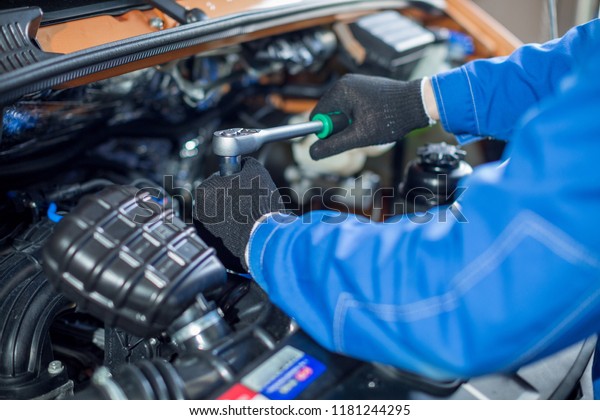 hands\
of a worker tightening a bolt in the motor\
vehicle
