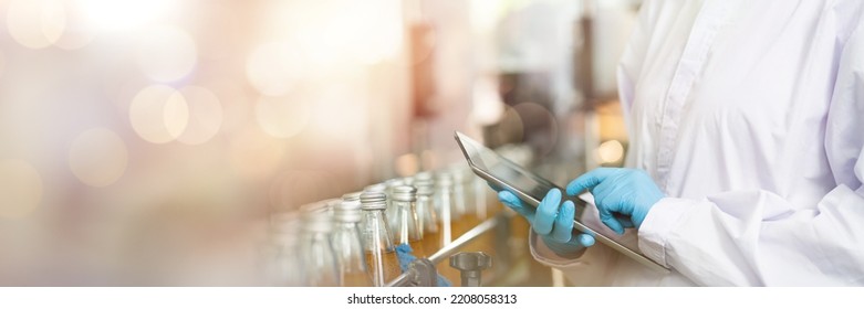 Hands of worker working with digital tablet check product on the conveyor belt in the beverage factory. Worker checking bottling line for processing. Inspection quality control - Shutterstock ID 2208058313