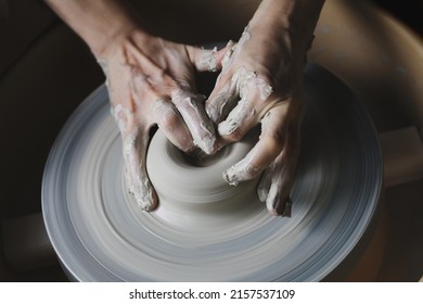 Hands working with clay on potter's wheel, craftsmanship, traditional craft making, pottery