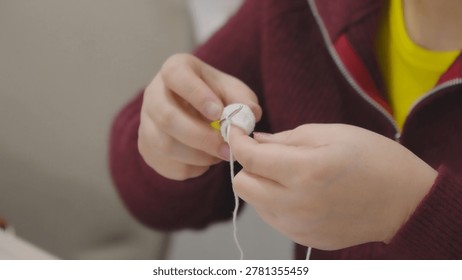 Hands working with needle while performing manual sewing close up in professiona