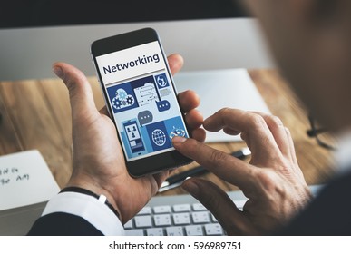 Hands working on digital device network graphic overlay