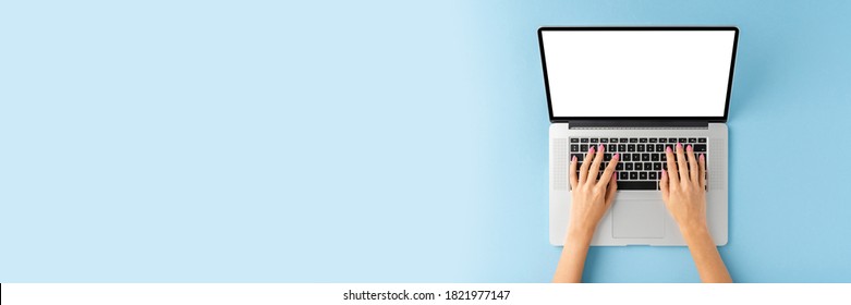 Woman’s hands working on laptop on blue background. Office desktop. Banner - Powered by Shutterstock