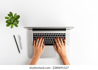 Woman’s hands working on laptop. Business background with accessories. Top view