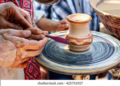 Hands Working On Pottery Wheel. Sculptor, Potter. Human Hands Creating A New Ceramic Pot. Female Potter Creating A Bowl On A Potters Wheel The Master Potter Helping Her. Pottery Skill Workshop Concept