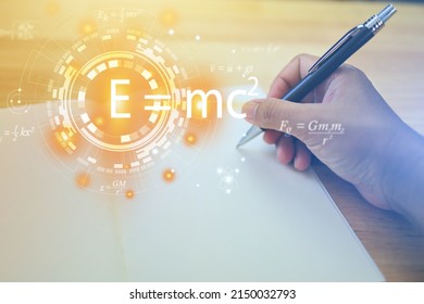 Hands Are Writing A Notebook With A Pen And Albert's Einstein General Relativity Equation. Physics Equations Floated In Light And Graphics. The Equation Is Emc2 Or Em C Square Student.