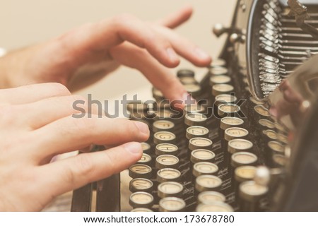 Hands writing on old typewriter