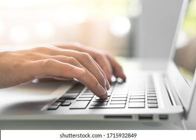 Hands writing ond a keyboard of a laptop or a notebook in Home Office