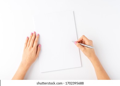 Woman’s Hands Writing With Pen Over Blank Paper Isolated On White Background. Top View