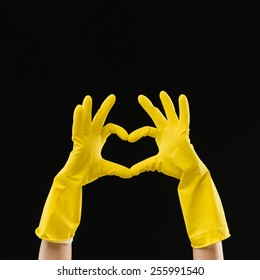 Hands In Yellow Rubber Gloves Making Heart Shape With Fingers, On Black Background