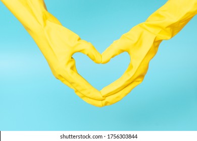 Hands In Yellow Rubber Gloves In The Shape Of A Heart On Blue Background